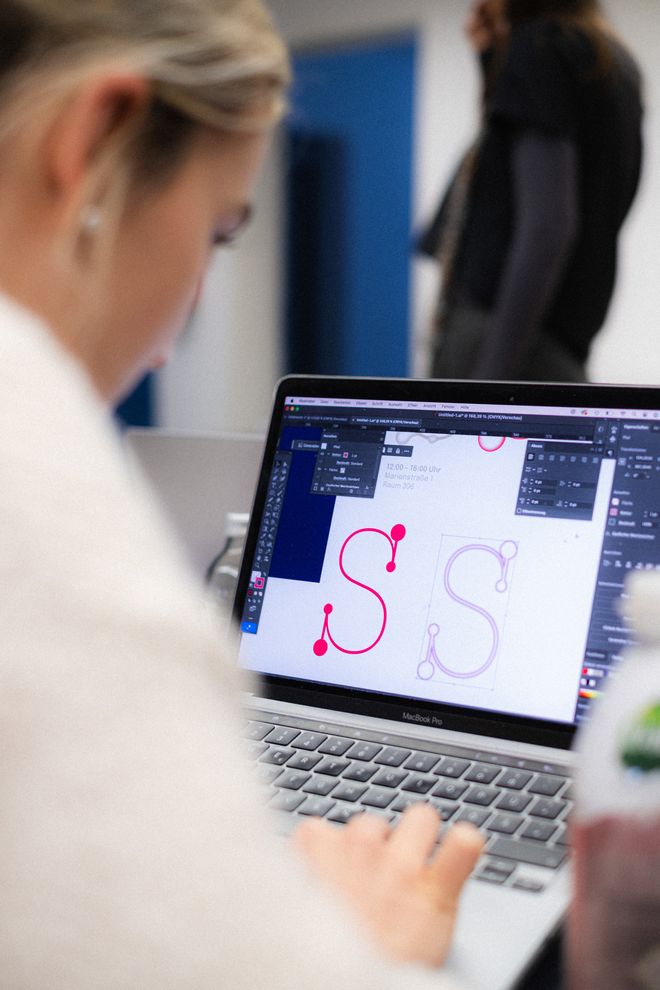 Projekt »Science, Bitch!«, Foto: Julian Linden eine Person von hinten fotografiert, arbeitet an einer Schrift auf ihrem Laoptop