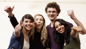 Foto: Jens Hauspurg Vier lachende und sich in den Armen liegende Internationale Studierende.