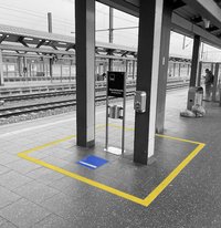 Photo of a yellow-marked smoking area at a railway station