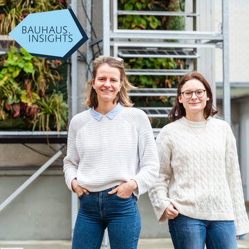 Maria Hartmann und Gloria Kohlhepp forschen gemeinsam, wenngleich aus unterschiedlichen Blickwinkeln an der multifunktionalen Fassade VertiKKA, die im Hintergrund zu sehen ist und aktuell in der Coudraystraße erprobt wird. Foto: Thomas Müller