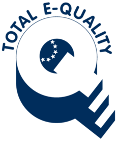 Das Logo des »Total E-Quality«-Prädikats besteht aus einem dreidimensionalen »Q« und dem Schriftzug »Total E-Quality«. Der Schrägstrich des Buchstabens »Q« hat die Form einer Treppe mit drei Stufen. Im Zentrum des »Q« deutet ein Halbkreis aus 6 Sternen die Europaflagge an.