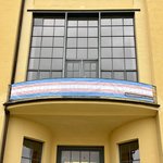 Das Banner in den Farben der Trans-Pride-Flagge am Balkon des Hauptgebäudes.